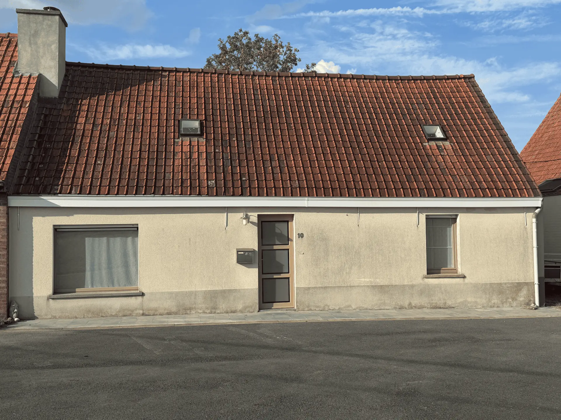 Voorgevel van de halfopen woning aan de straatkant met rood pannendak